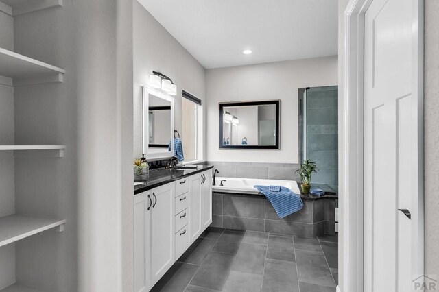 bathroom featuring double vanity, a bath, tile patterned flooring, a sink, and recessed lighting