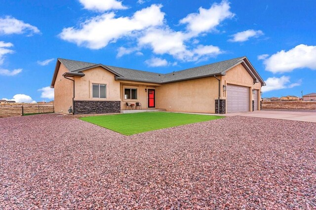 single story home featuring an attached garage, fence, stone siding, concrete driveway, and stucco siding