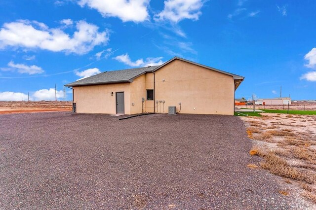 view of side of property with central AC and stucco siding