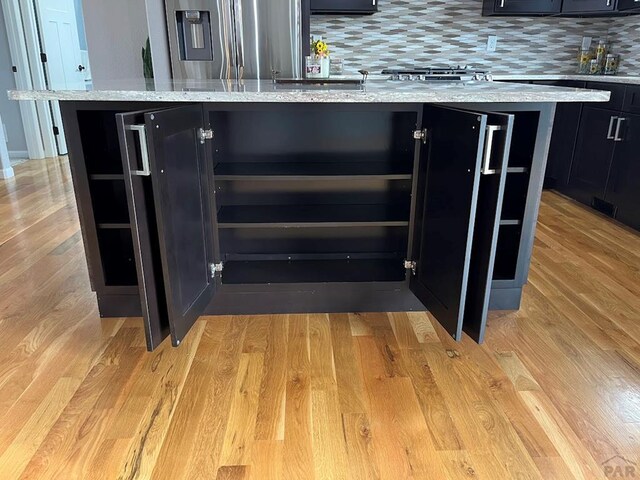 interior space featuring light wood-style floors, dark cabinetry, and a kitchen island