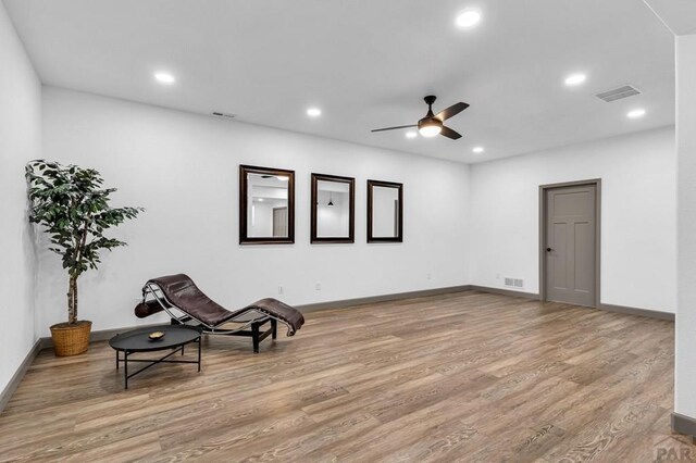 living area with light wood-type flooring, visible vents, and recessed lighting