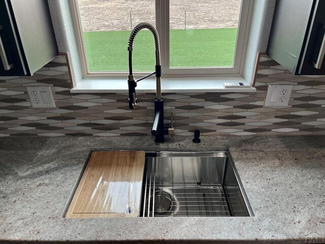 room details with tasteful backsplash, green cabinetry, and a sink