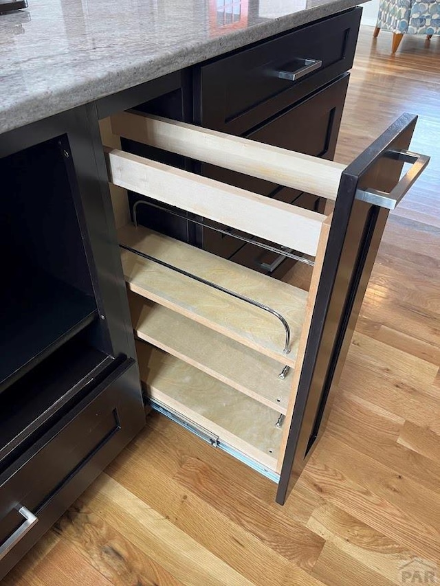 room details featuring light wood-style floors and dark cabinetry