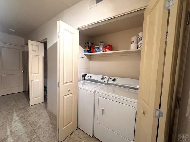 washroom with light tile patterned floors, laundry area, independent washer and dryer, and visible vents