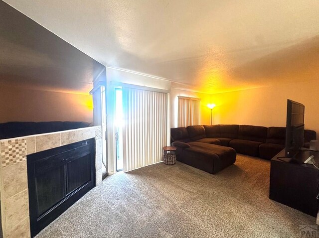 living room with carpet floors and a tile fireplace