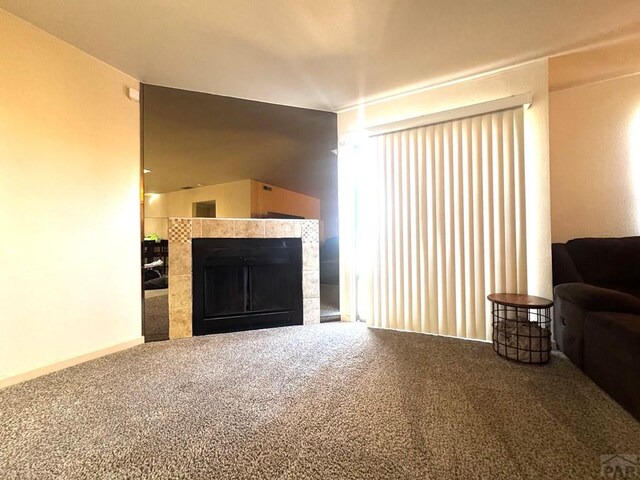 carpeted living room with a tiled fireplace