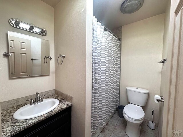 full bathroom with tile patterned flooring, curtained shower, vanity, and toilet