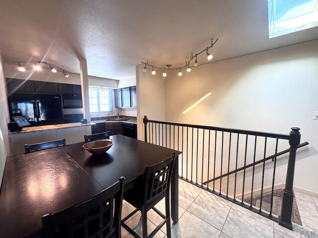 dining area with light tile patterned flooring and a textured ceiling