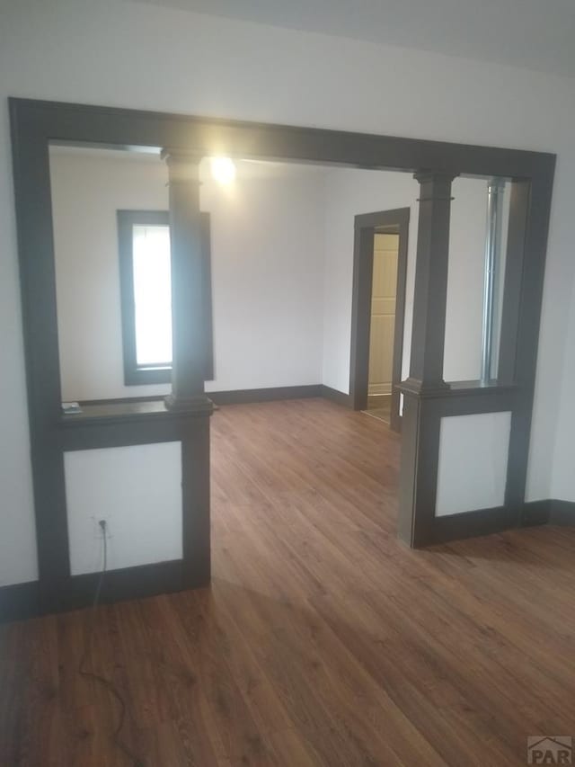 118 S 1st St, Cheraw, CO 81030 - spare room with wood finished floors, baseboards, and decorative columns