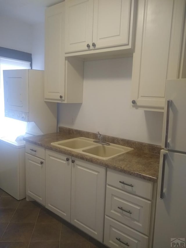 118 S 1st St, Cheraw, CO 81030 - kitchen featuring freestanding refrigerator, a sink, white cabinetry, and dark tile patterned floors
