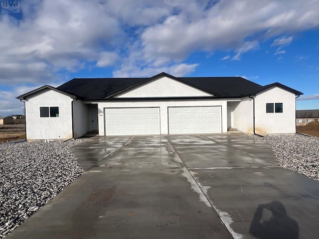 ranch-style home with driveway, an attached garage, and stucco siding