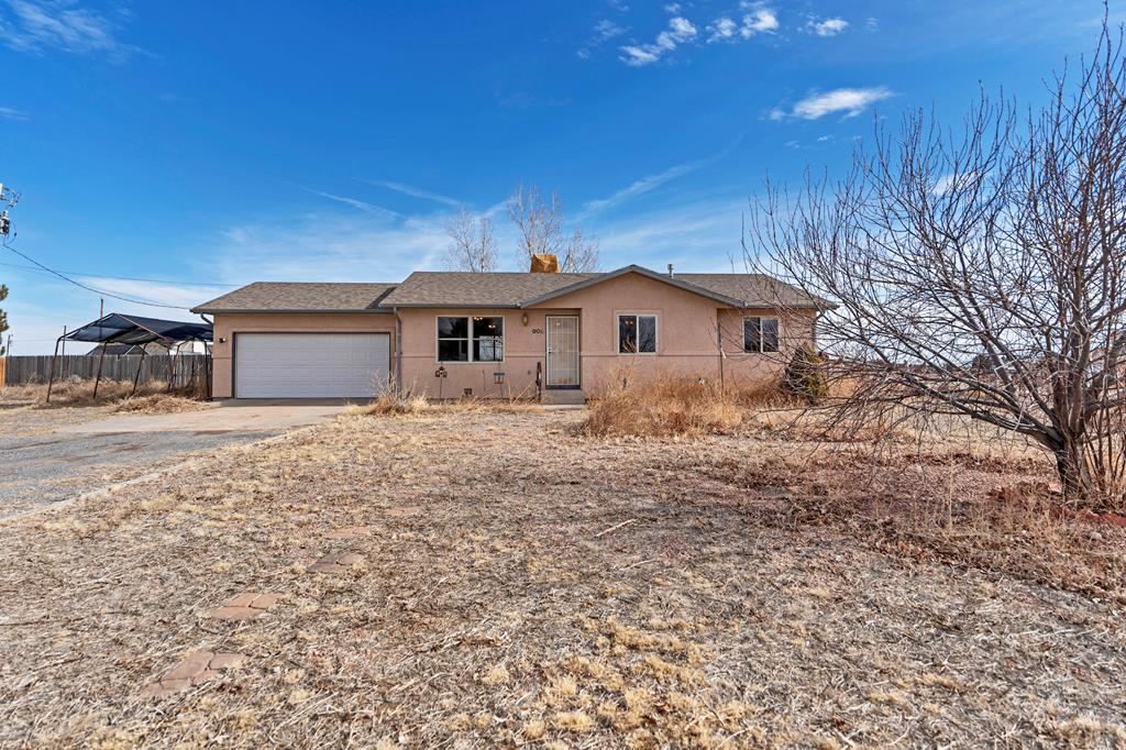 single story home featuring a garage, driveway, fence, and stucco siding