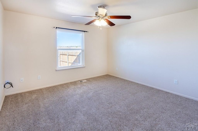 carpeted empty room featuring baseboards, a ceiling fan, and visible vents