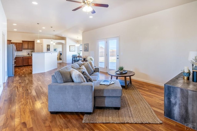 living room with recessed lighting, dark wood-style floors, vaulted ceiling, arched walkways, and ceiling fan