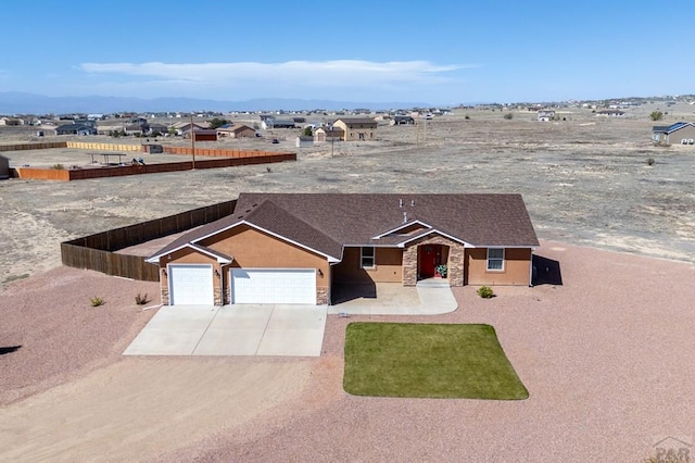 single story home with concrete driveway, stucco siding, stone siding, and a garage