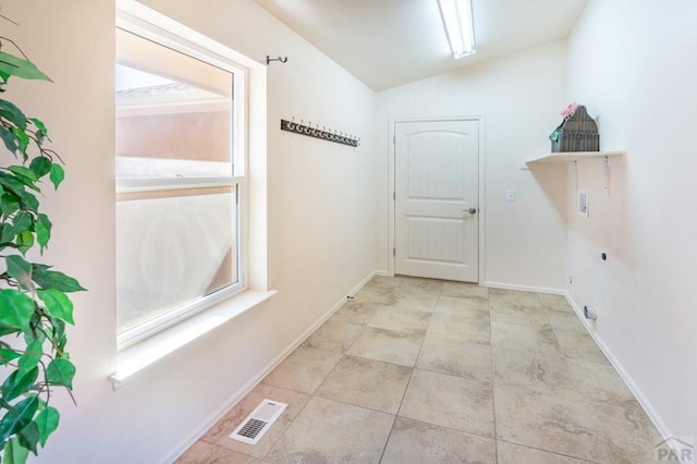interior space with lofted ceiling, baseboards, and visible vents