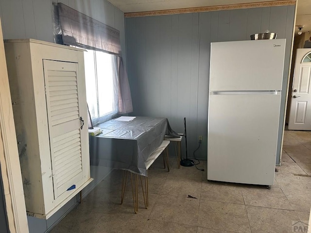 kitchen featuring light tile patterned floors and freestanding refrigerator