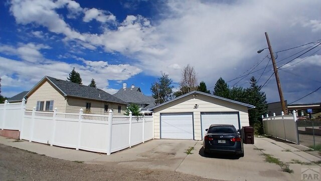 detached garage featuring fence