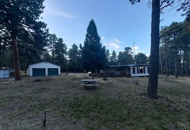 view of yard featuring a garage and an outbuilding