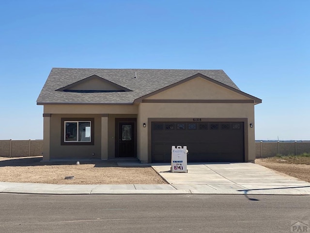 ranch-style home featuring an attached garage, driveway, fence, and stucco siding