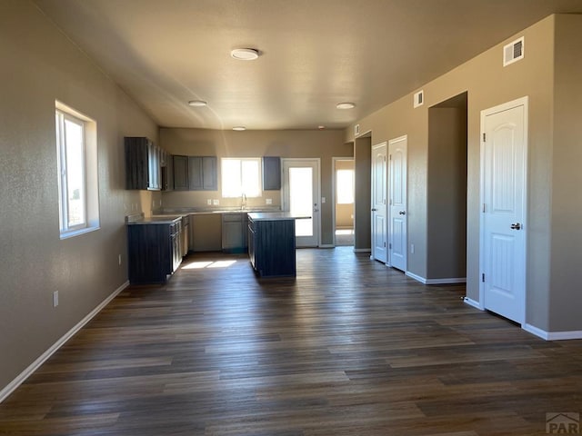 kitchen featuring plenty of natural light, baseboards, visible vents, and dark wood finished floors