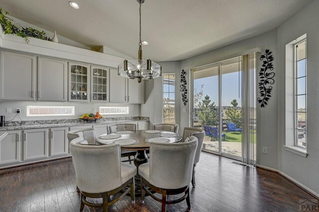 10919 Cascading Spring Cir, Peyton, CO 80831 - dining space featuring a chandelier, dark wood-style flooring, recessed lighting, vaulted ceiling, and baseboards