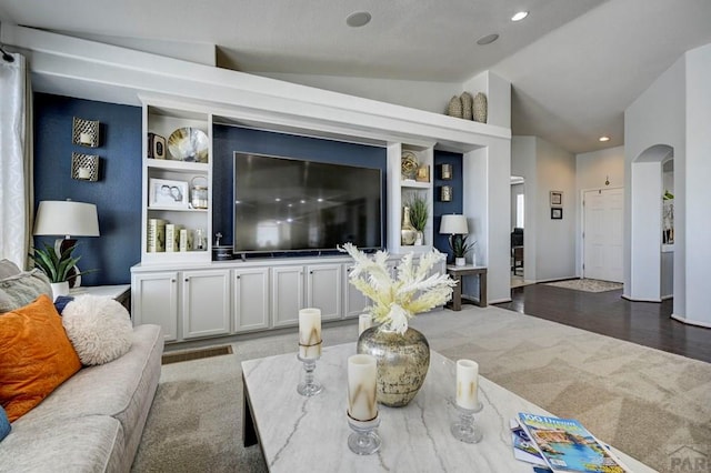 10919 Cascading Spring Cir, Peyton, CO 80831 - carpeted living room with lofted ceiling, built in shelves, arched walkways, and recessed lighting