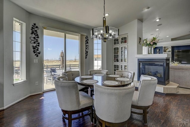 10919 Cascading Spring Cir, Peyton, CO 80831 - dining area with dark wood finished floors, a chandelier, a glass covered fireplace, recessed lighting, and baseboards