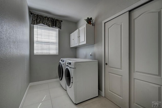 10919 Cascading Spring Cir, Peyton, CO 80831 - washroom with washing machine and clothes dryer, light tile patterned floors, baseboards, and cabinet space