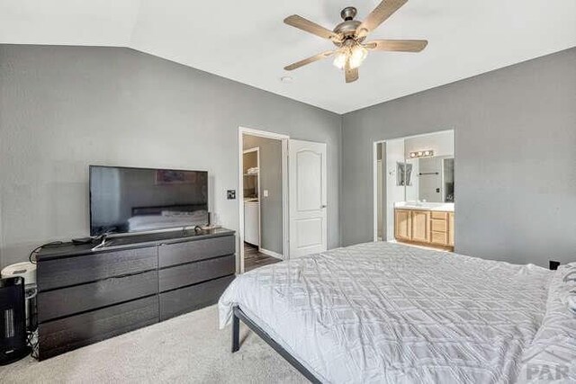 bedroom with a ceiling fan, lofted ceiling, connected bathroom, and carpet floors