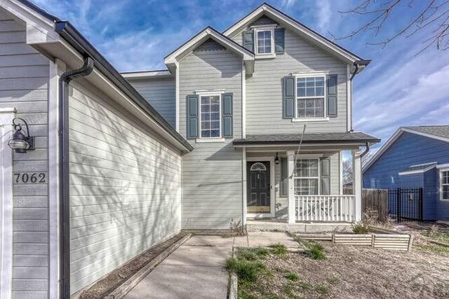 view of front of house featuring fence and a porch