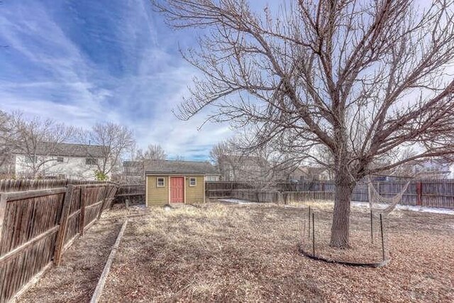 view of yard featuring an outbuilding, a storage shed, and a fenced backyard