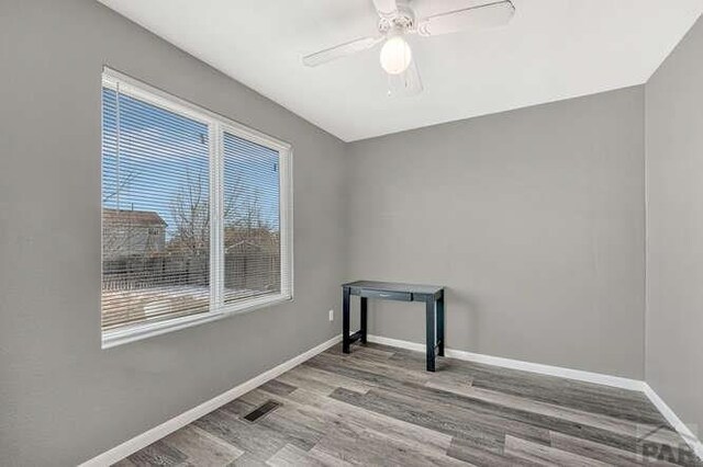 unfurnished room featuring visible vents, a ceiling fan, light wood-style flooring, and baseboards