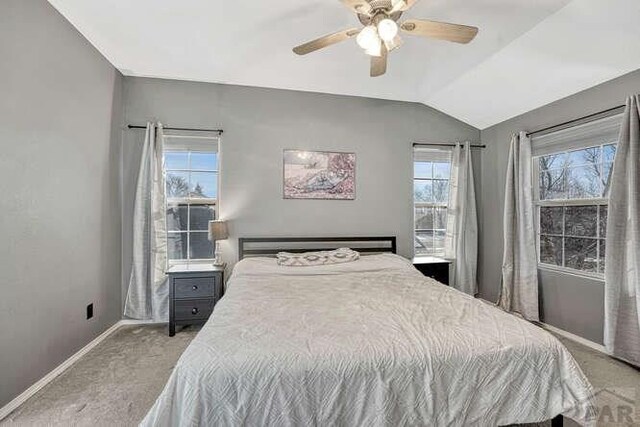 bedroom featuring ceiling fan, baseboards, vaulted ceiling, and light colored carpet