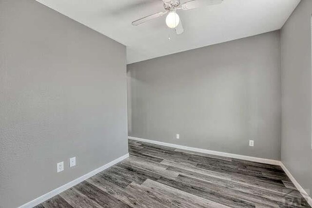 spare room with ceiling fan, baseboards, and wood finished floors