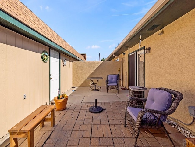 view of patio / terrace with central air condition unit and fence