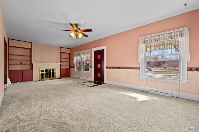 unfurnished living room with visible vents, carpet, baseboards, a brick fireplace, and ceiling fan