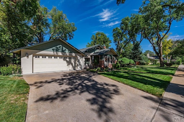 view of front facade with a garage, a front yard, and driveway