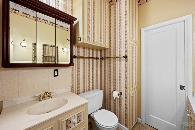 half bath featuring decorative backsplash, wallpapered walls, toilet, and vanity