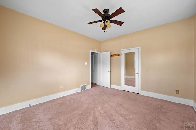 unfurnished bedroom featuring visible vents, baseboards, carpet, and a ceiling fan