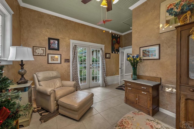 sitting room with light tile patterned floors, a ceiling fan, baseboards, french doors, and crown molding