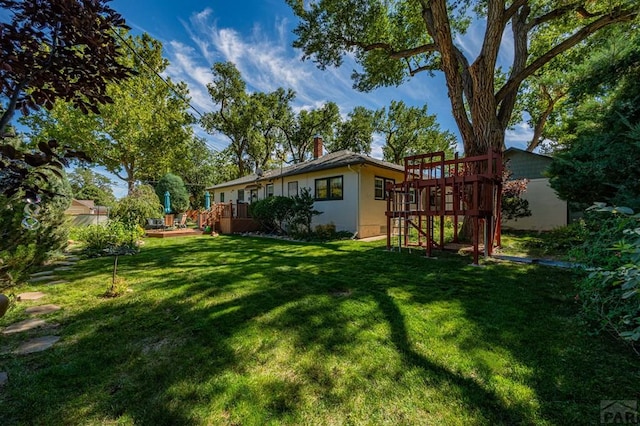 view of yard featuring a playground and a wooden deck