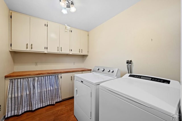 laundry area with washer and clothes dryer, cabinet space, and dark wood-type flooring