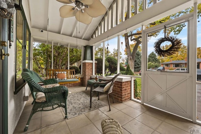 sunroom featuring vaulted ceiling and a ceiling fan