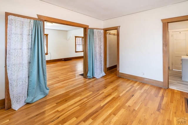 empty room featuring baseboards, visible vents, and light wood-style floors