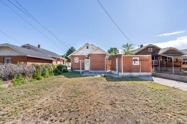 exterior space with a yard, brick siding, and fence