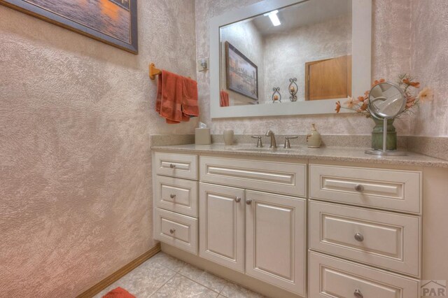 bathroom with baseboards, vanity, and tile patterned floors