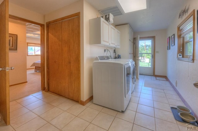 209 E Francisco St, La Veta, CO 81055 - laundry room featuring a healthy amount of sunlight, cabinet space, washing machine and dryer, and light tile patterned floors