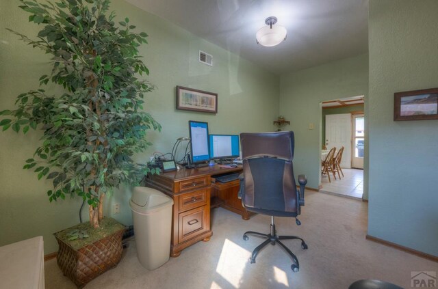 office featuring baseboards, visible vents, and light colored carpet