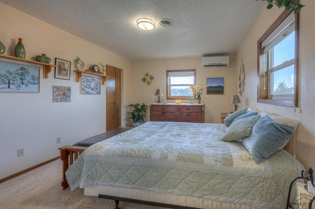 bedroom featuring a textured ceiling, a wall mounted AC, carpet, and baseboards